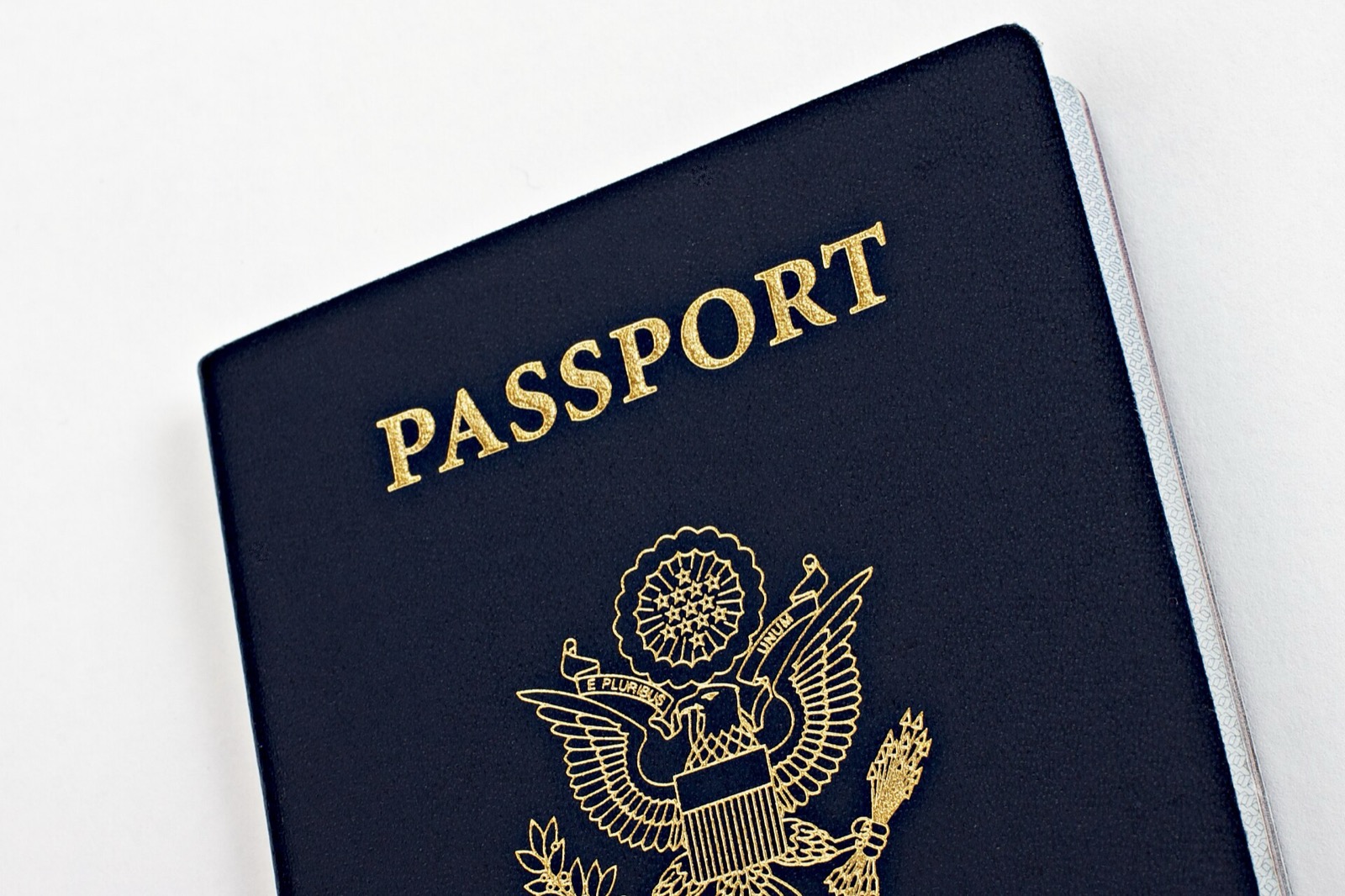 Closed navy-blue United States passport book with the word PASSPORT and the national seal in gold
